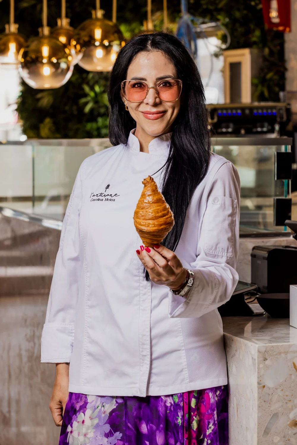 Chef Carolina Molea holding a croissant inside L’Artisane