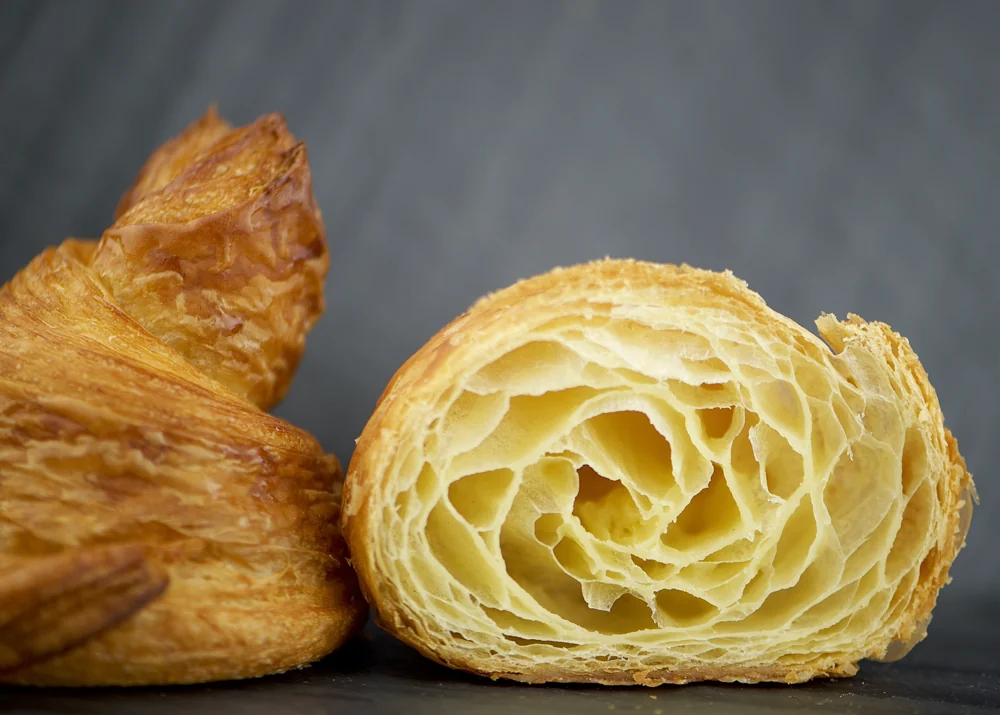 A L’Artisane croissant sliced open to show its delicate, honeycomb-like layers